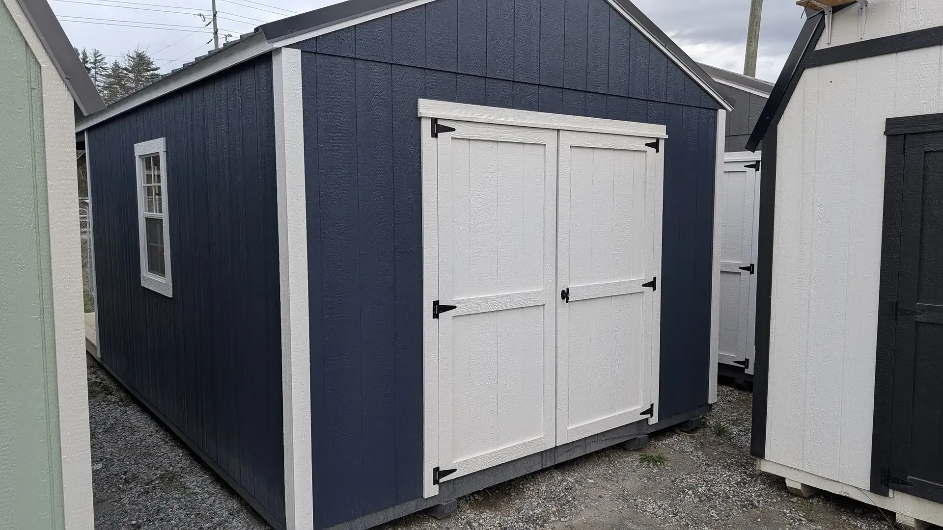 Blue and white shed with double doors and a small window.
