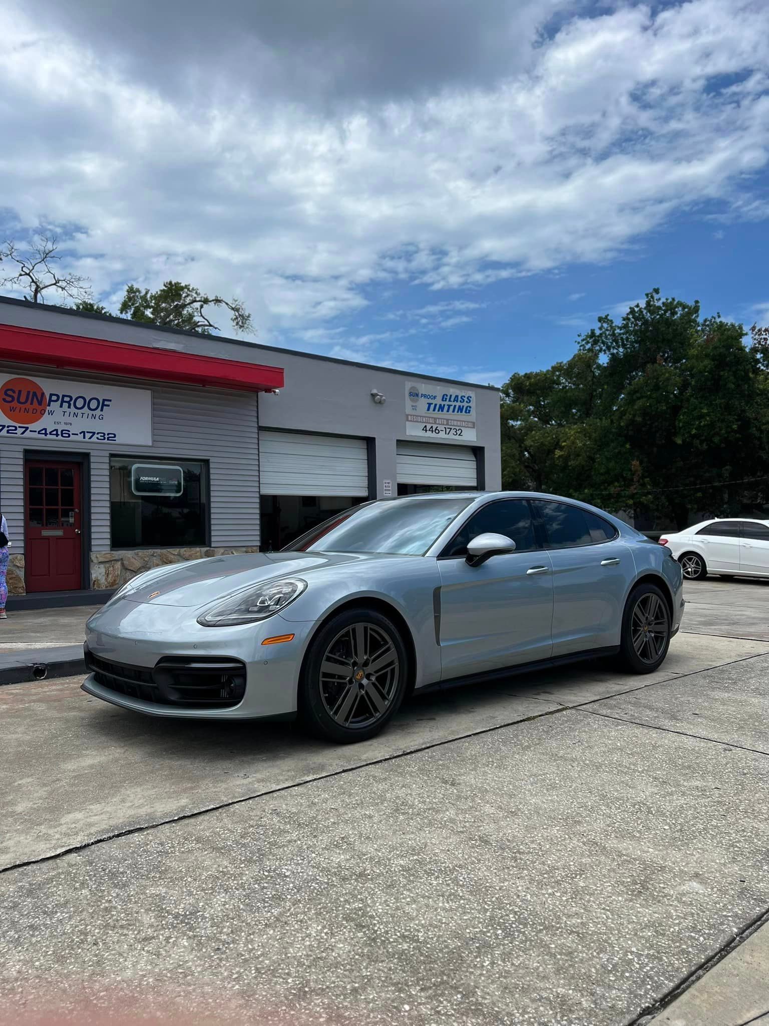 Silver sedan parked outside a storefront on a cloudy day