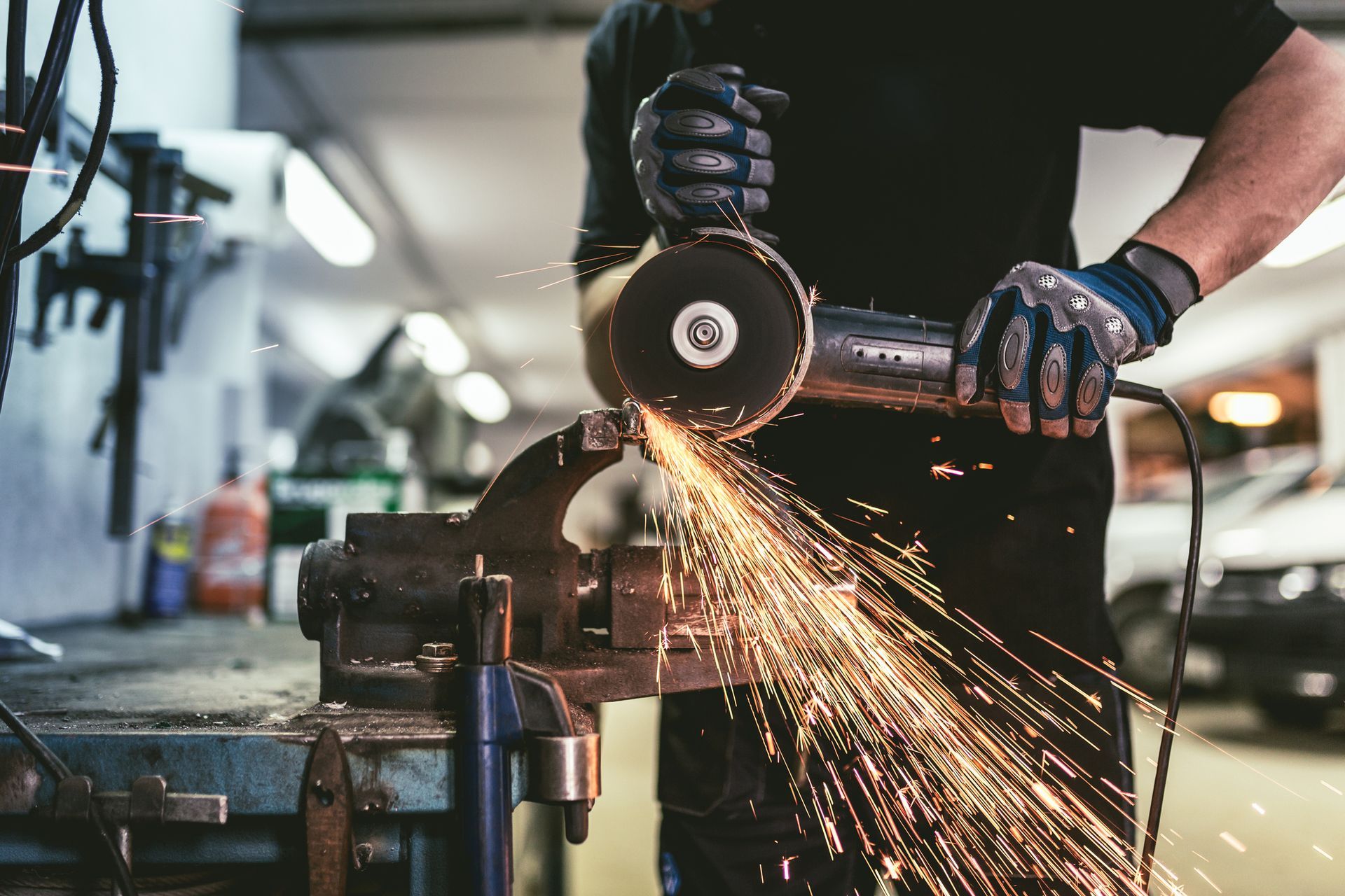 A man is holding a drill and wearing a tool belt.