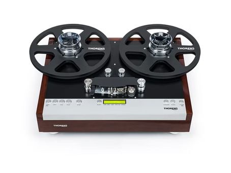 Reel-to-reel tape recorder, wooden base, black reels, control panel with buttons, and display.