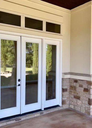 There are two sliding glass doors on the side of a building.
