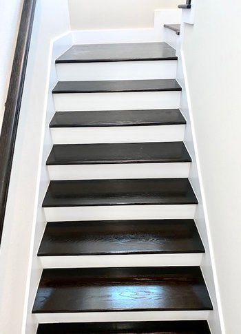 A set of stairs with black steps and white risers