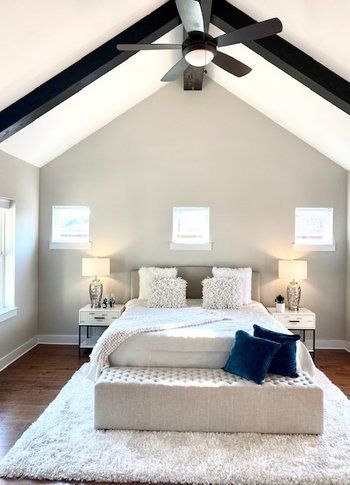 A bedroom with a vaulted ceiling and a large bed.