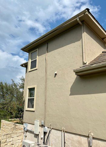 The side of a house with a lot of windows and a roof.