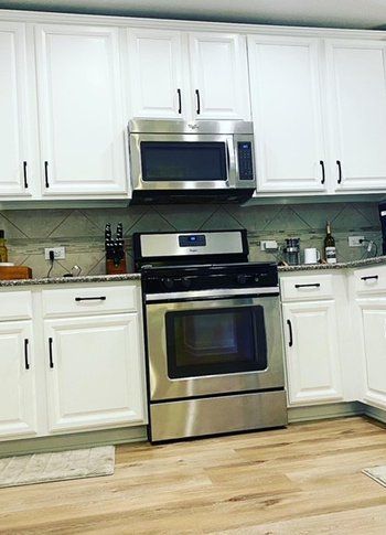 A kitchen with stainless steel appliances and white cabinets
