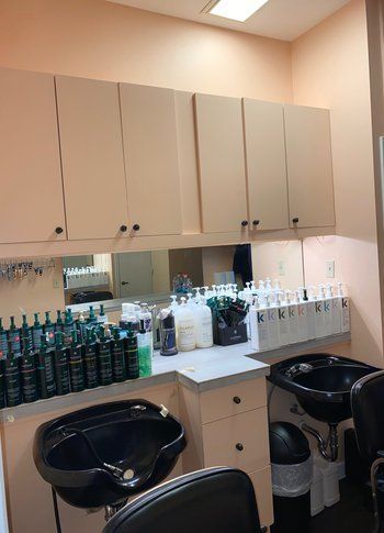 A hair salon with two sinks and a mirror.