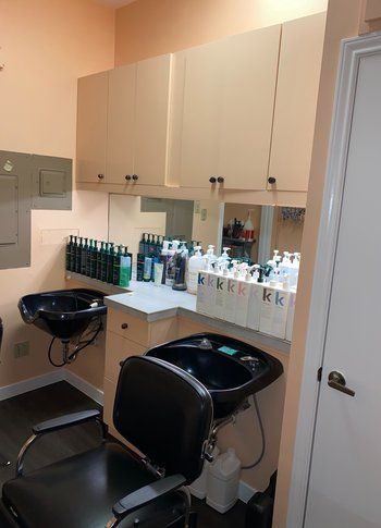 A hair salon with two sinks and a chair.