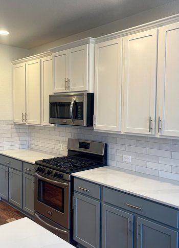 Home in Austin, TX that had kitchen remodel including cabinet painting, new countertops, and new backsplash completed by Austin Painting and Cabinets