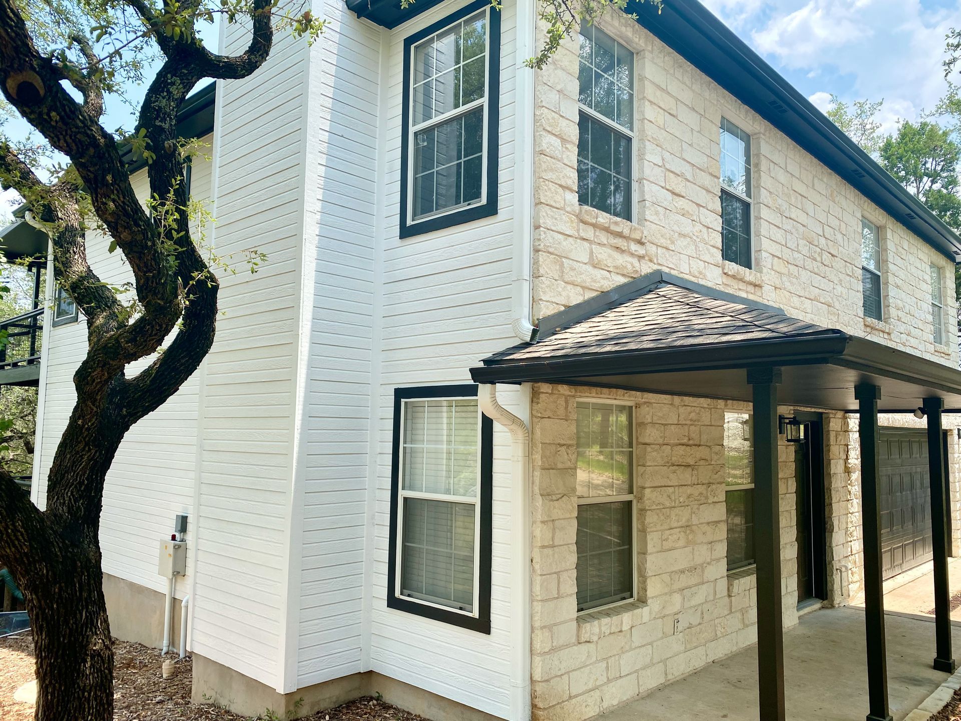 After photo of Austin exterior painting project with updated siding trim doors and preserved stone exterior