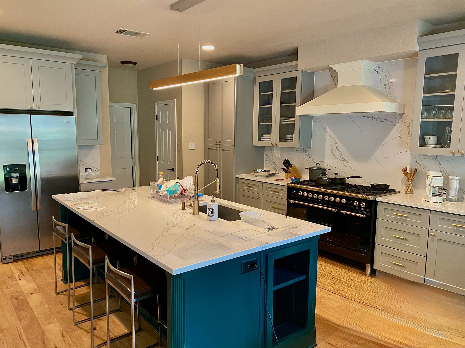 Austin kitchen remodel in Circle C with new shaker perimeter cabinets painted island cabinets quartz countertops and updated layout