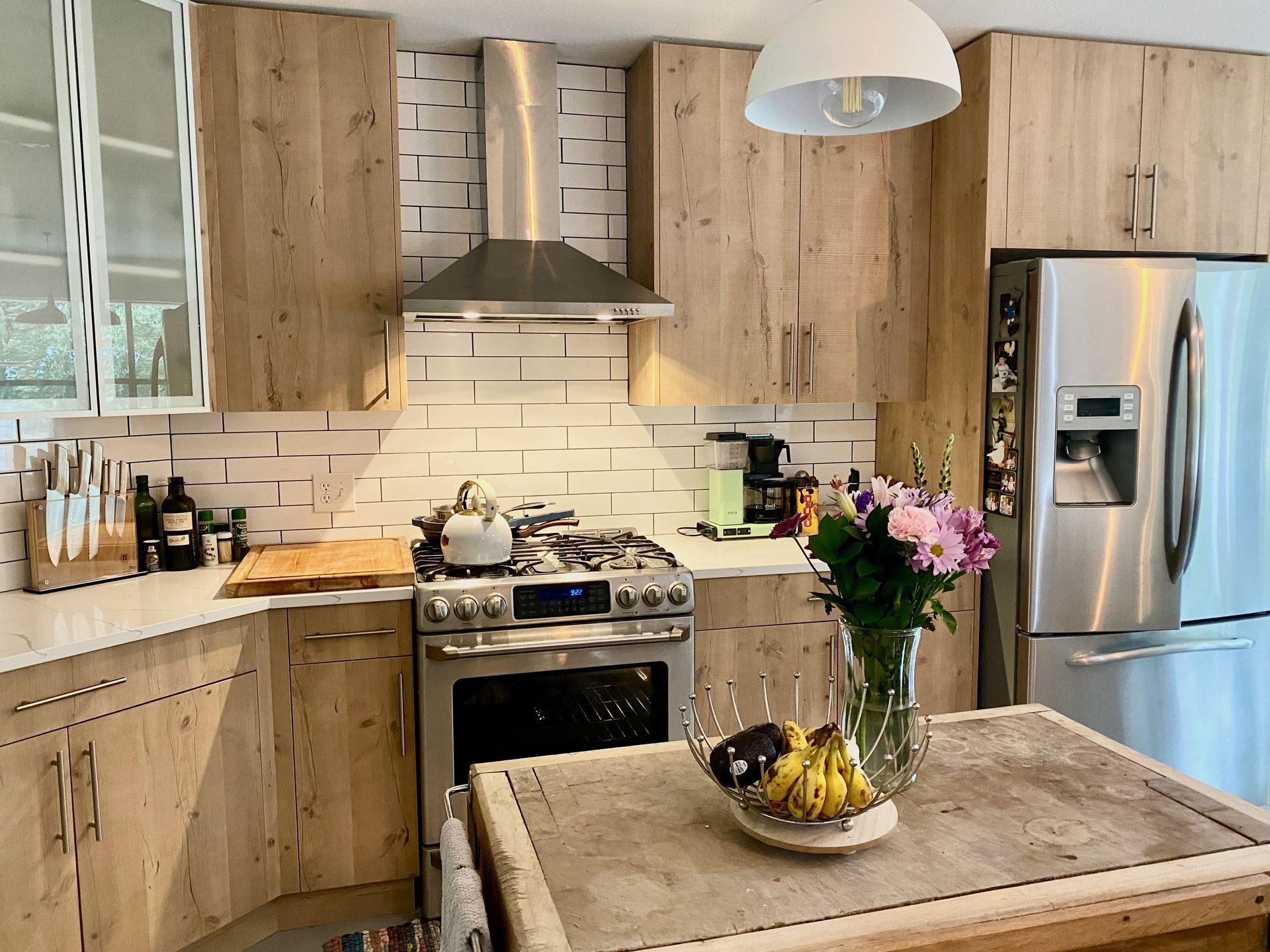 Kitchen remodel in Dripping Springs featuring European style Rustic Oak frameless cabinets Calacatta Ultra quartz countertops and tile backsplash