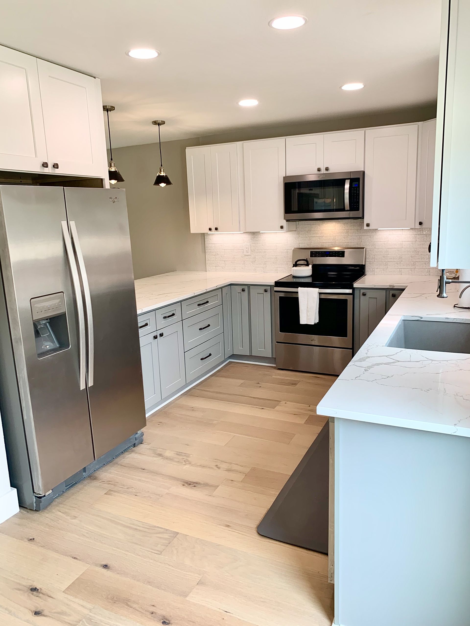 After photo of Dripping Springs kitchen remodel near Austin with open concept shaker cabinets quartz countertops tile backsplash and new flooring