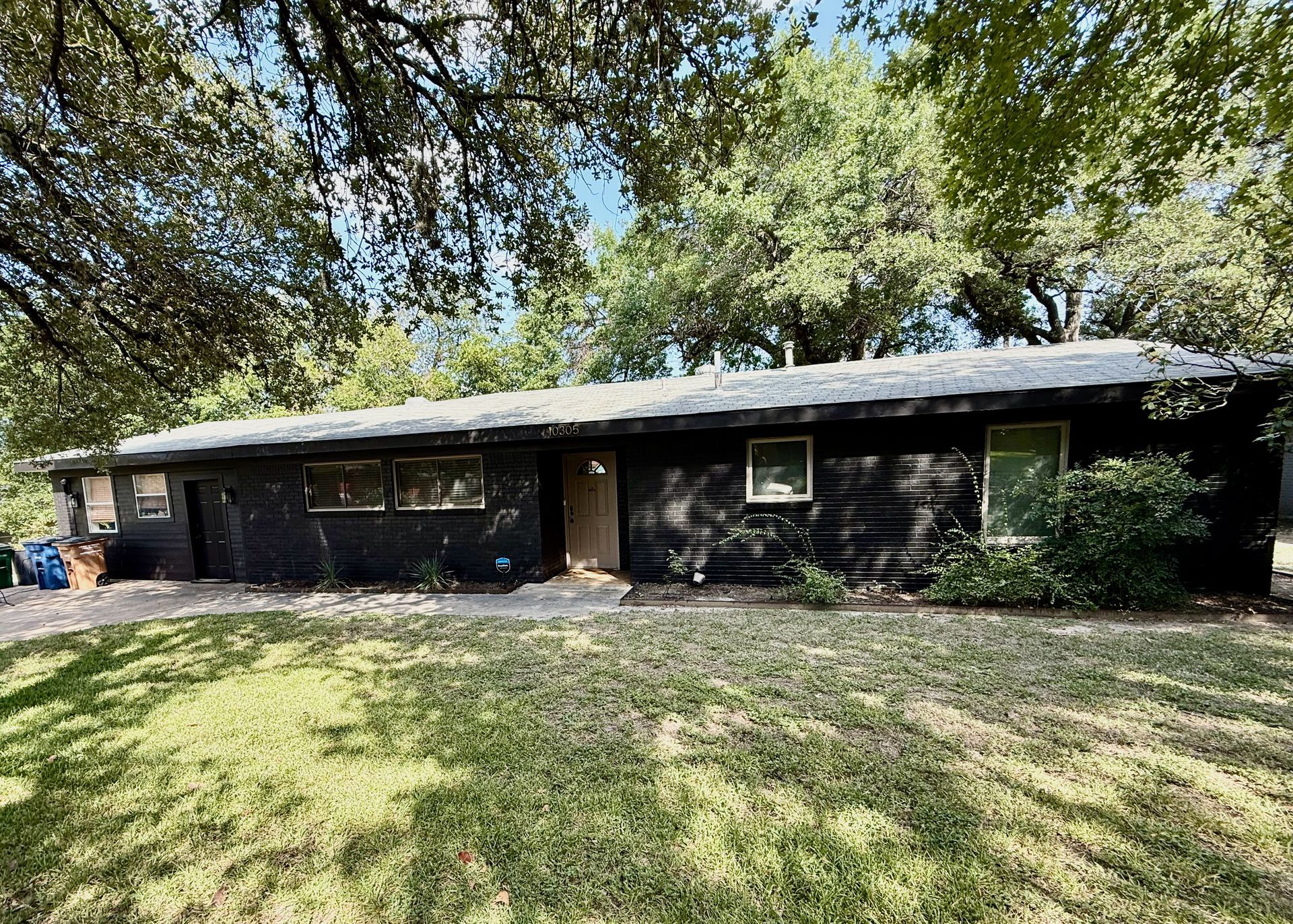 North Austin exterior painting project with Sherwin-Williams Caviar on brick siding doors patio and