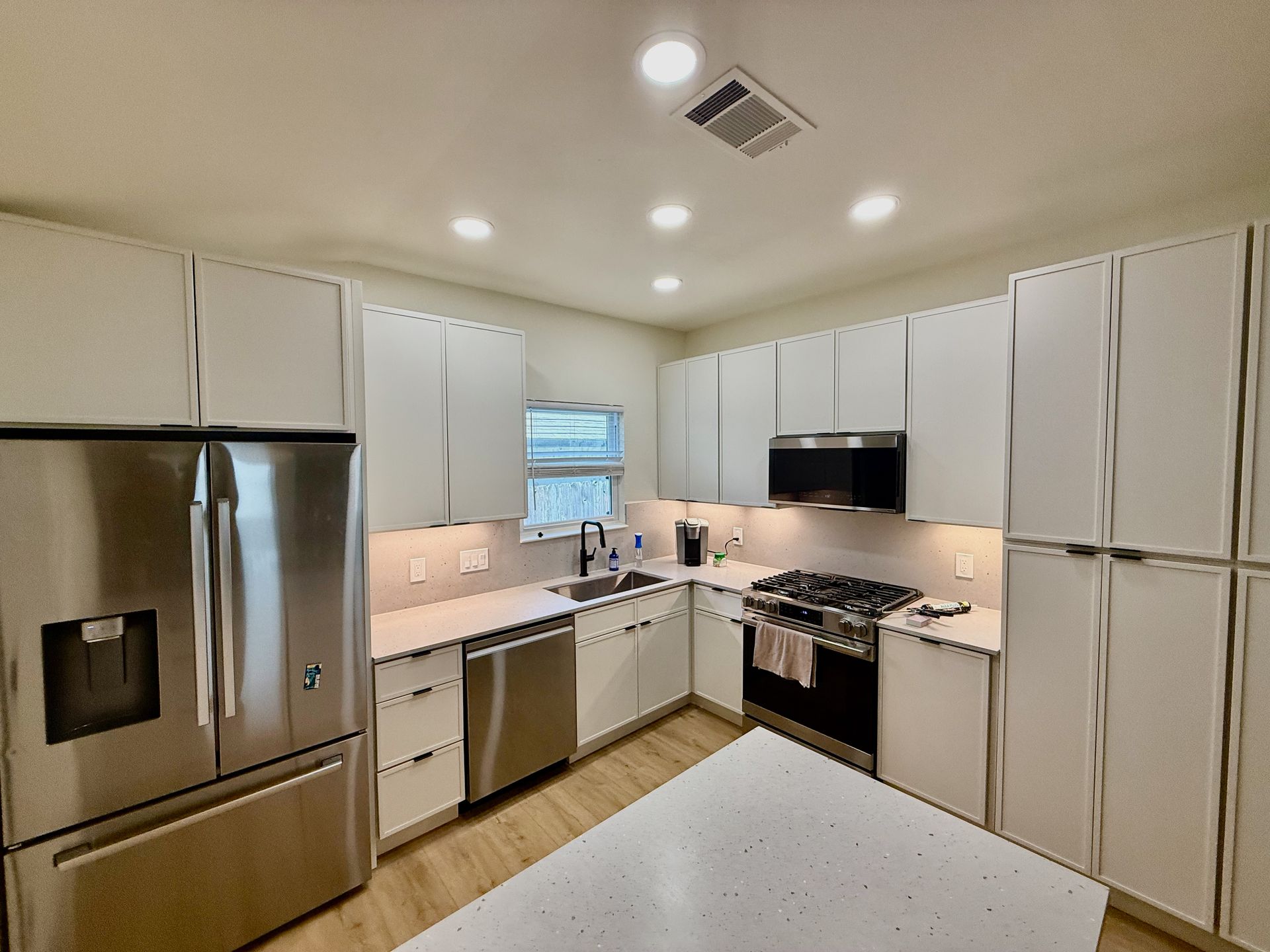 Northwest Austin kitchen remodel with new slim shaker cabinets quartz countertops and matching quartz backsplash