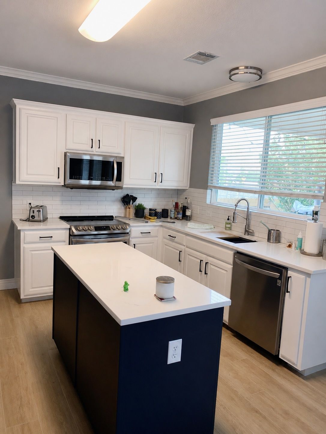 Round Rock kitchen remodel with Decorator’s White cabinets Hale Navy island Calacatta Mirragio quart