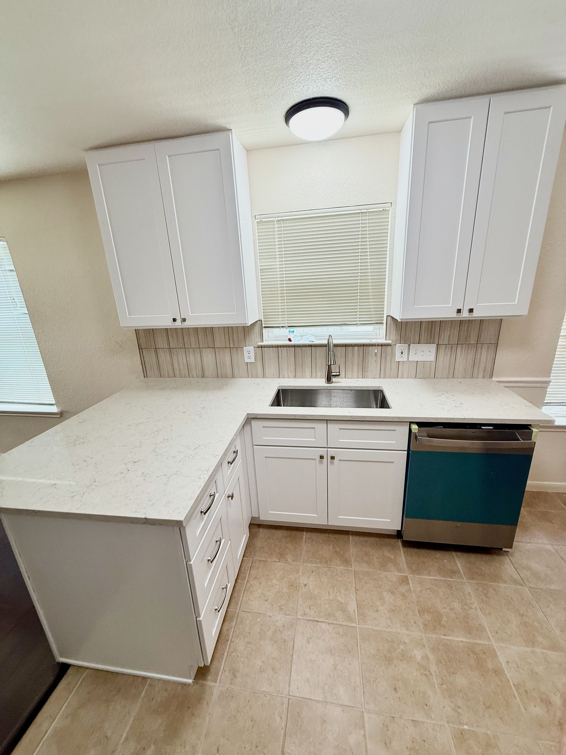 Round Rock kitchen remodel with new white shaker cabinets extending to ceiling and Carrara Mist quartz countertops