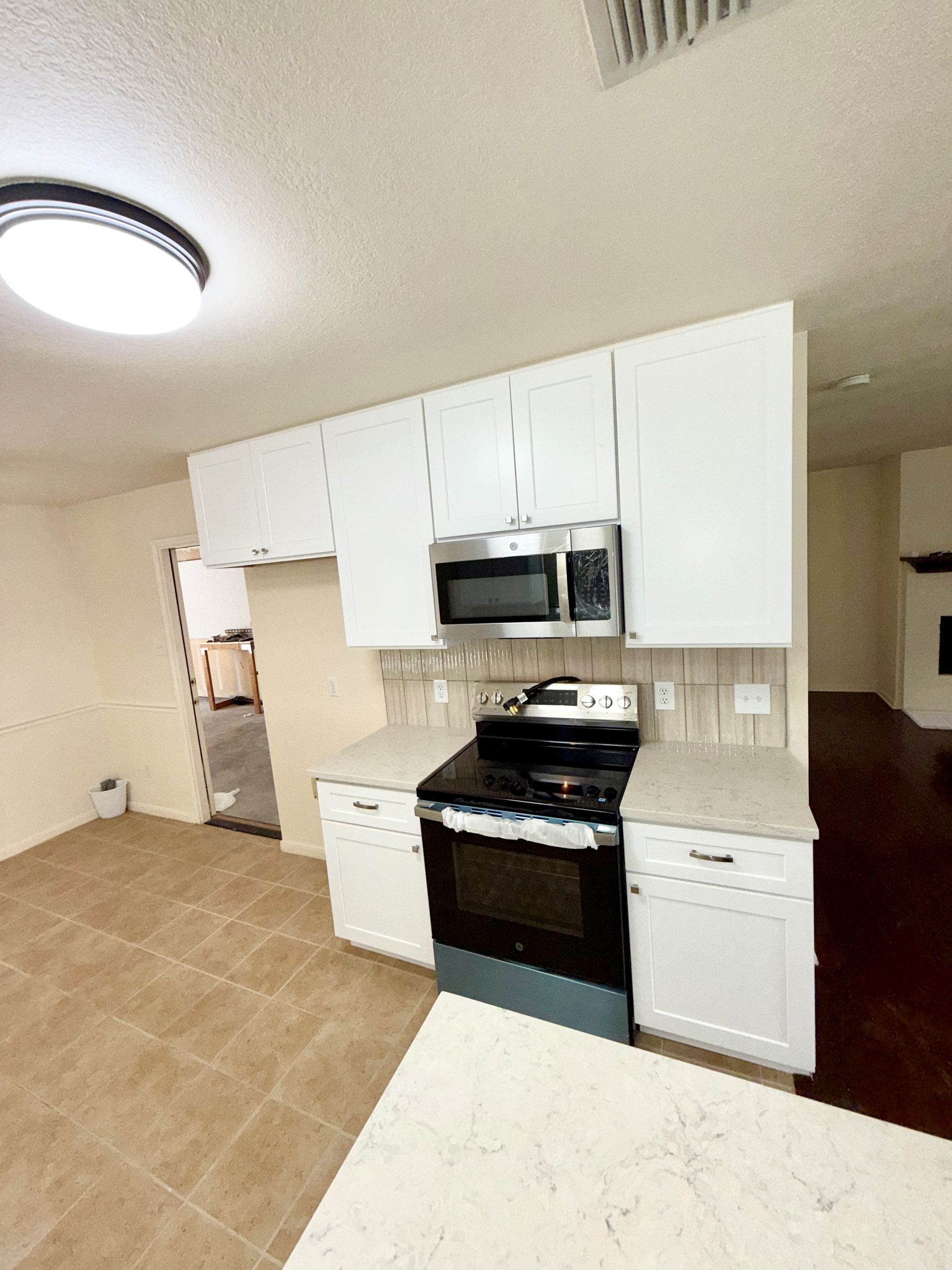 Remodeled Round Rock kitchen with white shaker cabinets MSI Gems Cappuccino backsplash and undermount sink