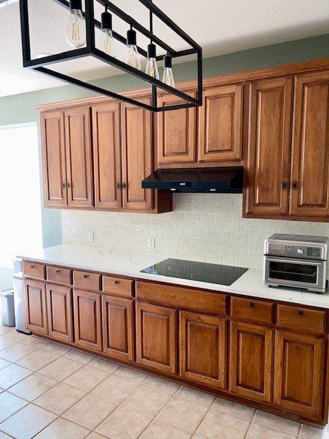 A kitchen with wooden cabinets and white counter tops