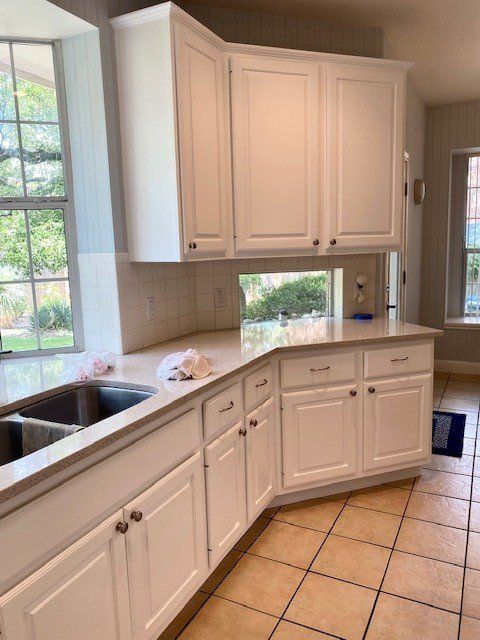 A kitchen with white cabinets and a sink