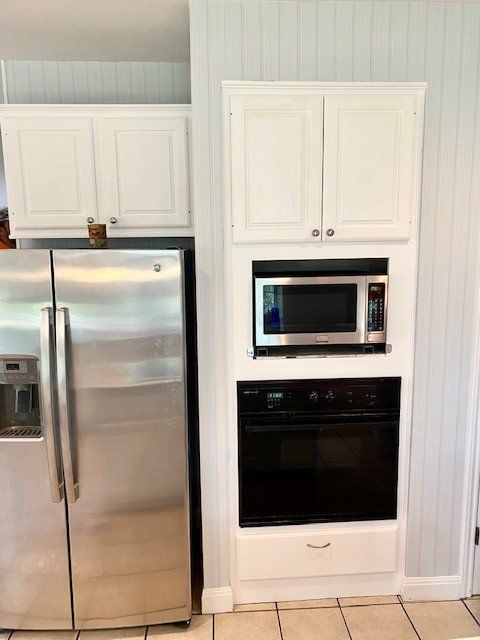 A kitchen with stainless steel appliances and white cabinets