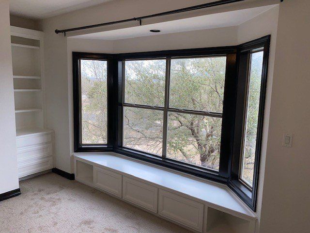 An empty room with a bay window and shelves