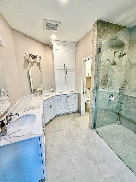 Cedar Park TX master bathroom remodel with curbless walk-in shower, freestanding tub, and quartz vanity
