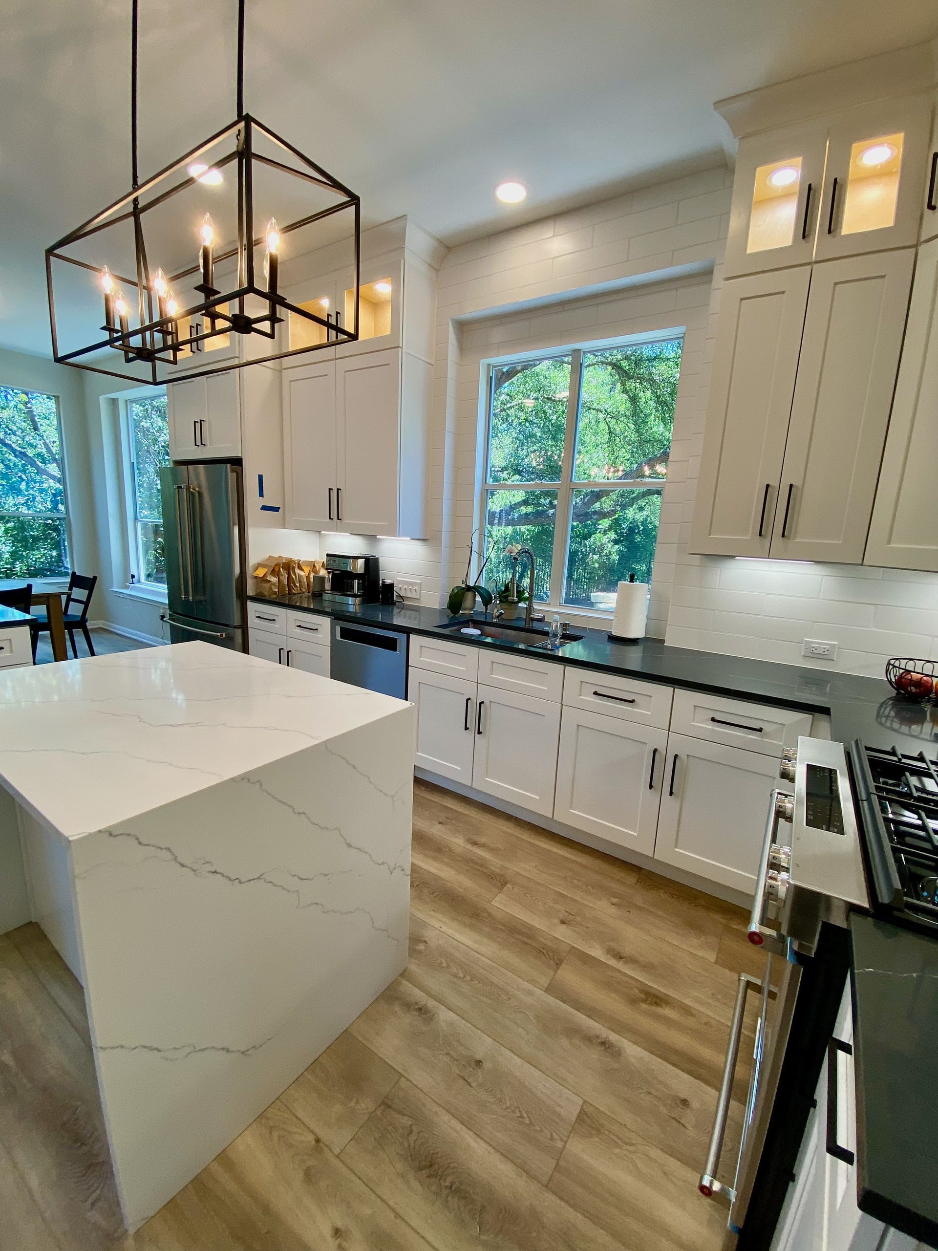 After photo of Circle C South Austin kitchen remodel with new cabinets quartz countertops waterfall island and backsplash