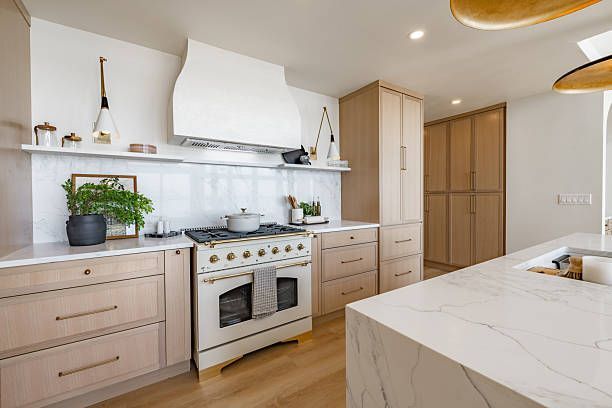 Kitchen remodel in Austin showing 2025 design trends with warm earthy cabinet colors, a multifunctional island, statement backsplash, and mixed metals