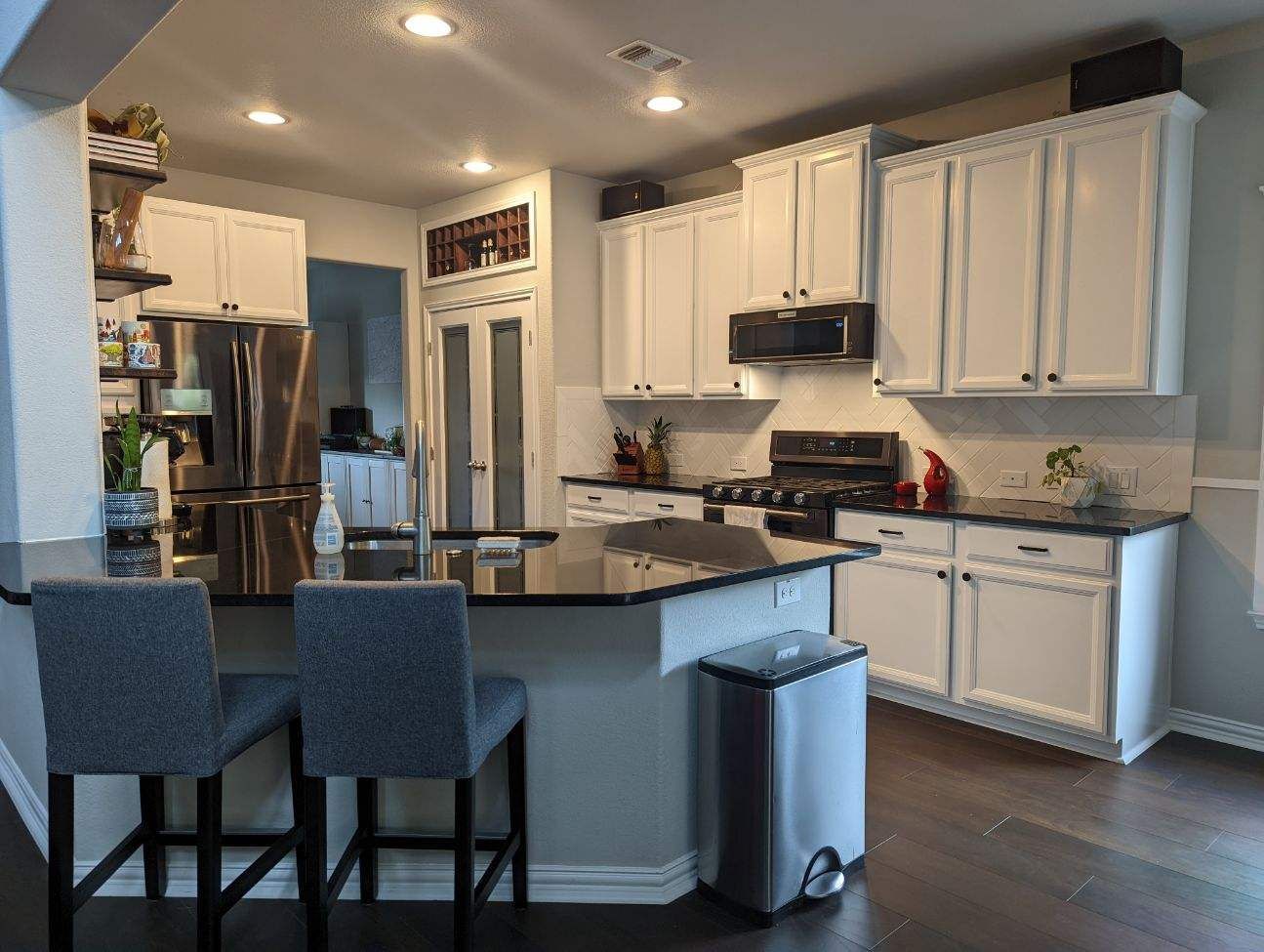 Oak Hill Austin kitchen remodel with Chantilly Lace cabinets, Silestone Iconic Black quartz countertops, and herringbone backsplash