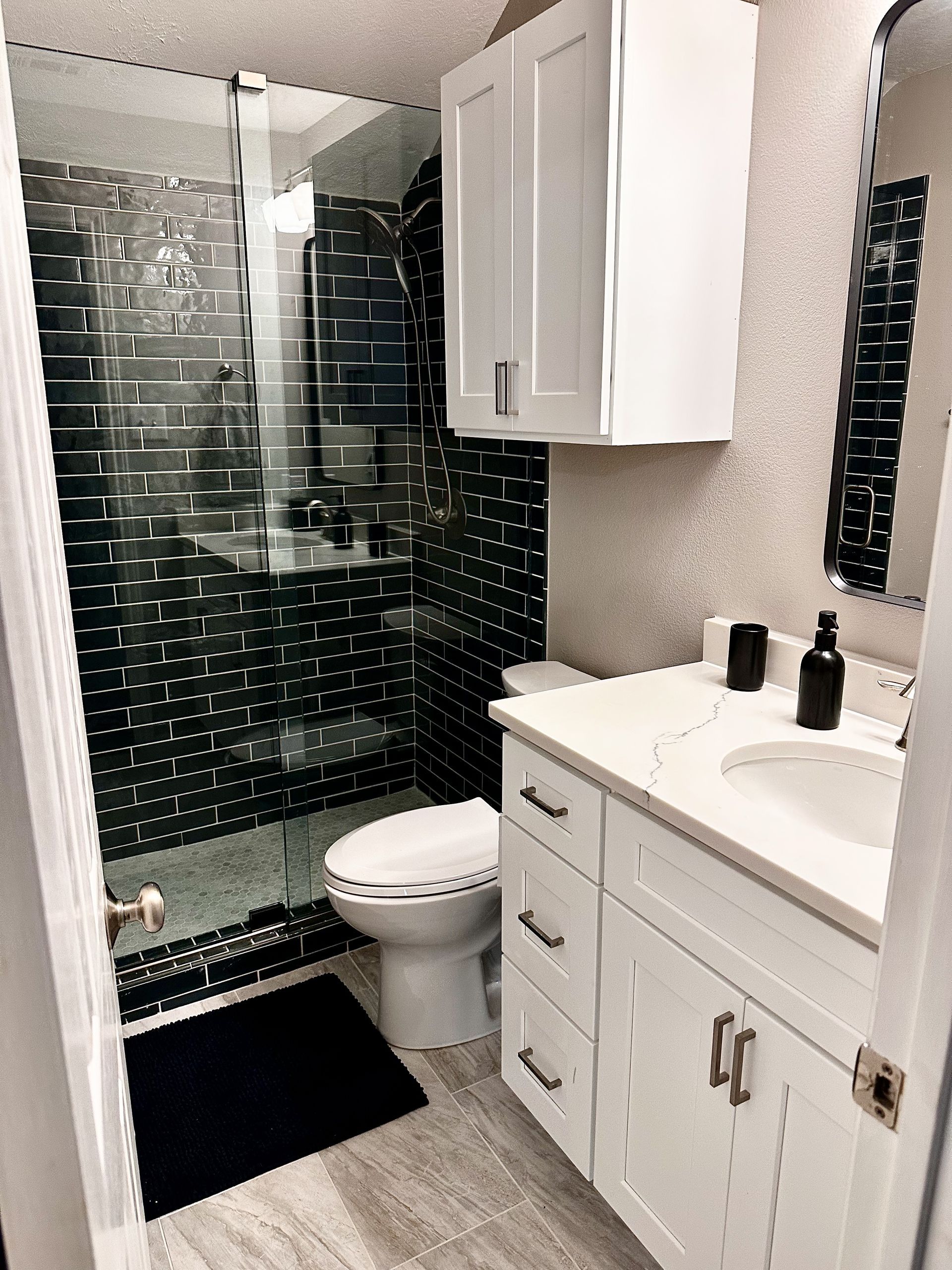 After photo of Northwest Austin guest bathroom remodel with tub to shower conversion tile frameless sliding glass vanity and lighting