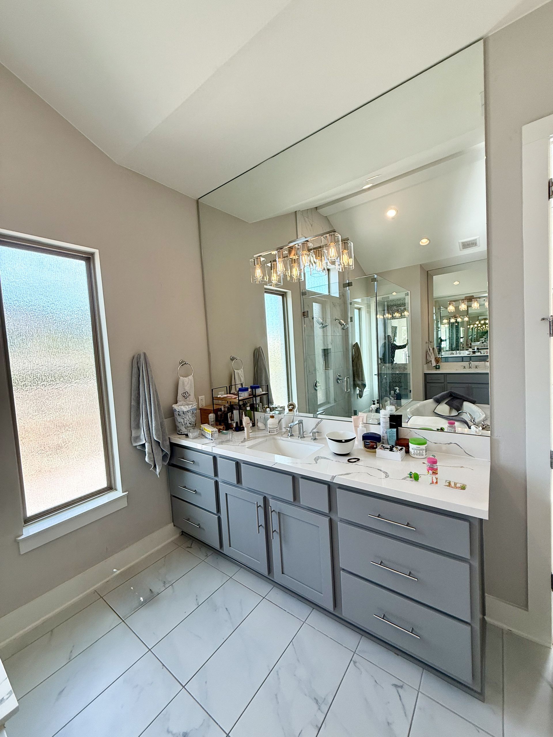 Southwest Austin bathroom remodel with frameless shower glass painted vanity cabinets quartz countertops and custom mirrors