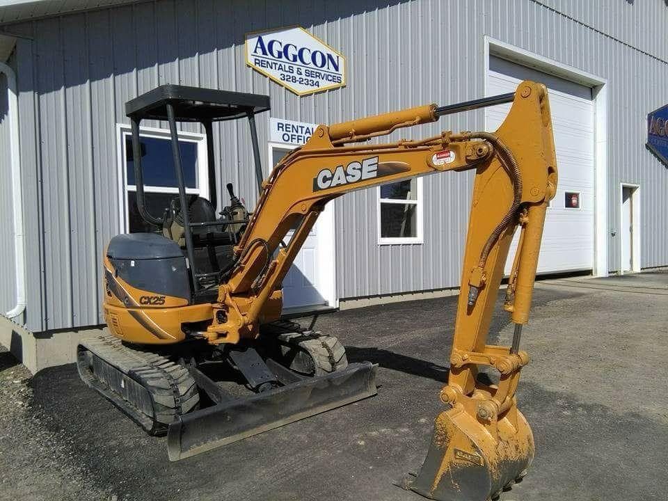 A case excavator is parked in front of a building