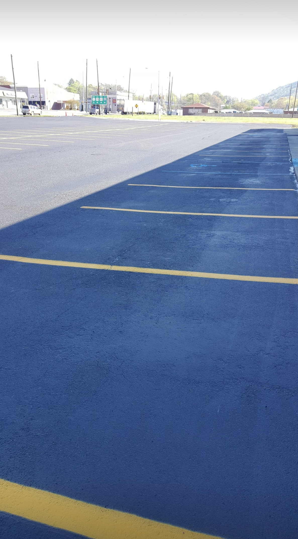 Empty asphalt parking lot with yellow lines.