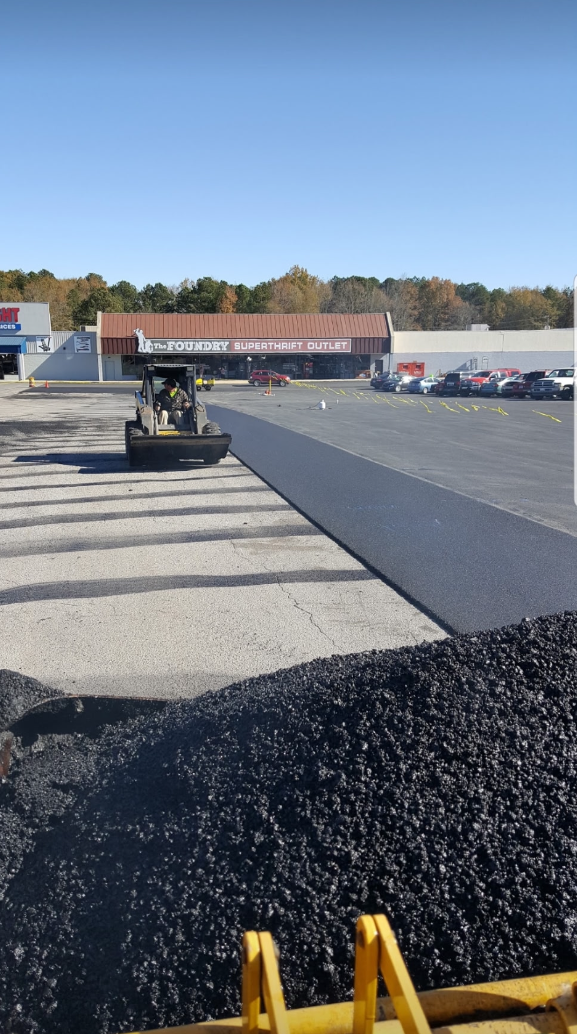 Asphalt road with several dark patches from repairs.