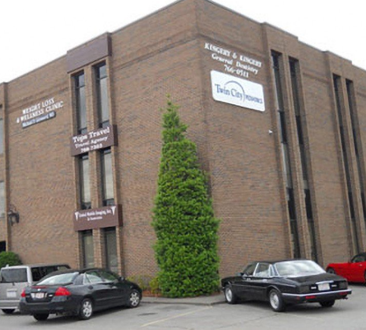 Cars are parked in front of a large brick building that says kingsley & kings