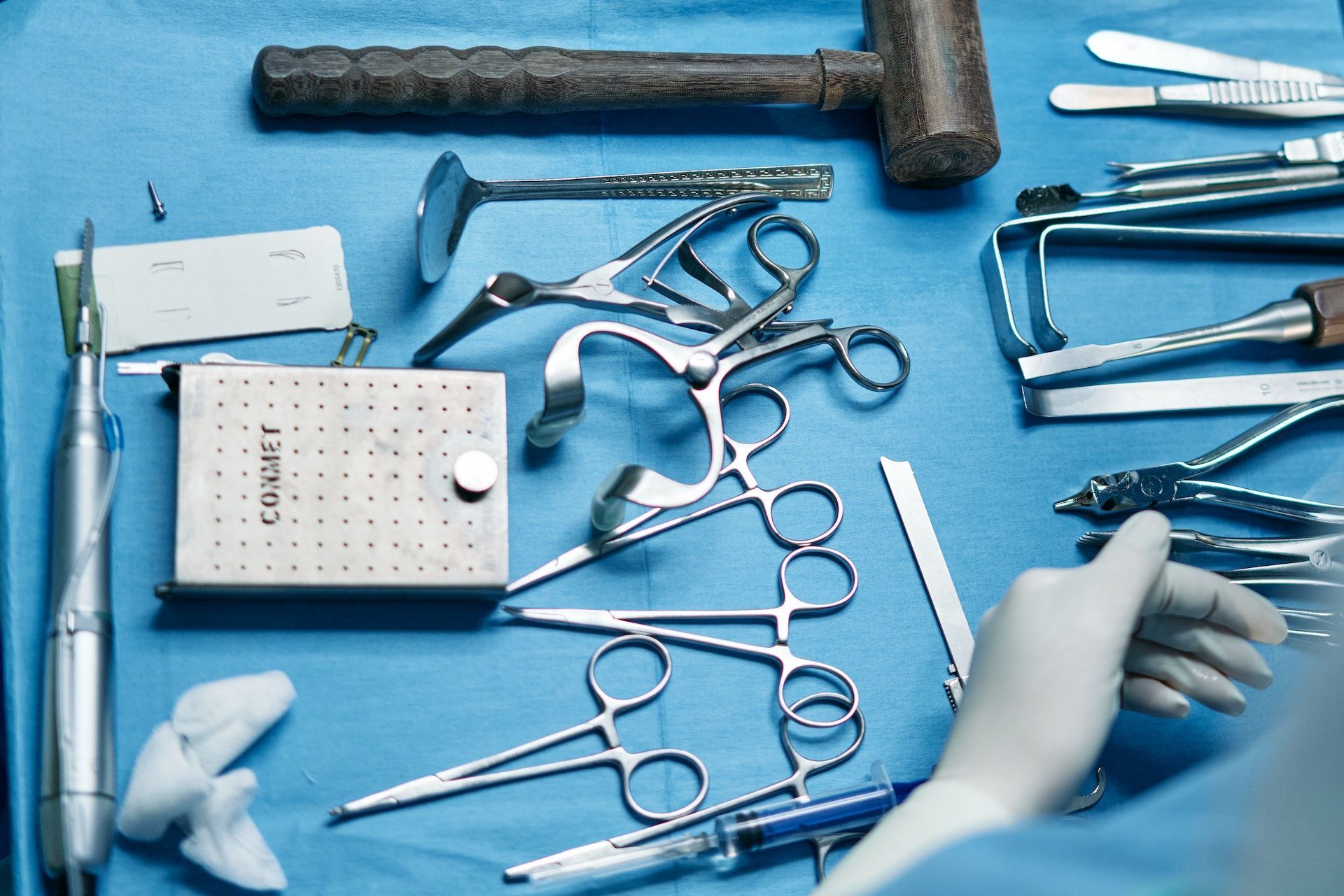A tray of surgical instruments including a hammer and scissors