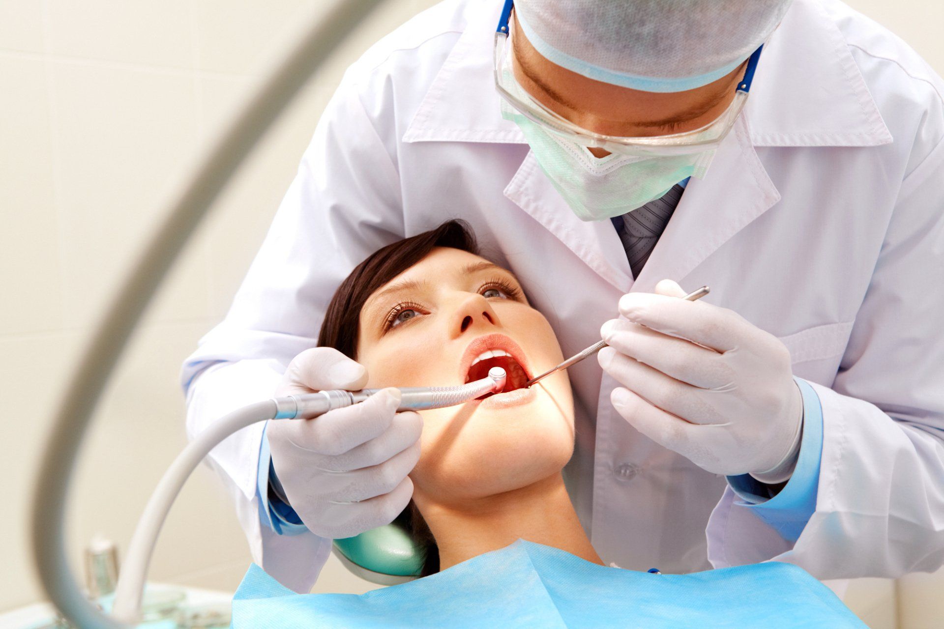 A woman is getting her teeth examined by a dentist.