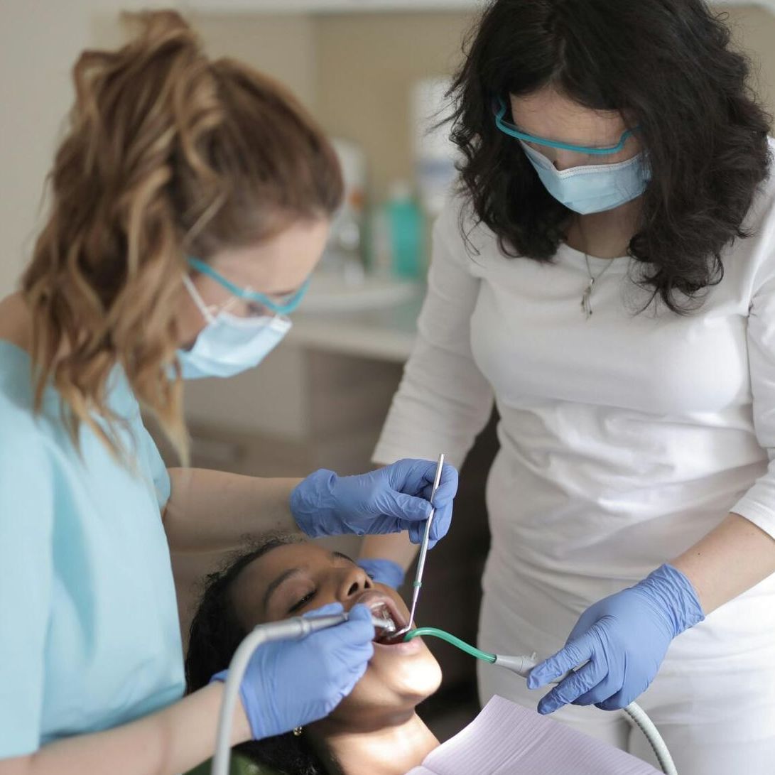 Una mujer se hace examinar los dientes por un dentista.