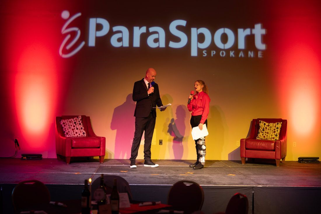 Emcee interviews an athlete in red on stage at Pairing with ParaSport 2025