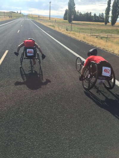 Racers with bibs 460 and 462 push side by side on a rural road