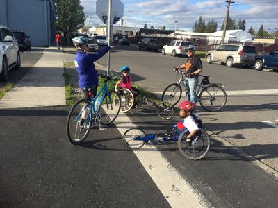 Coach points the way for young racers and cyclists at a street crossing