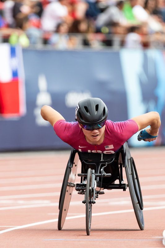 Phillip Croft in maroon pushes toward the camera, arms out wide