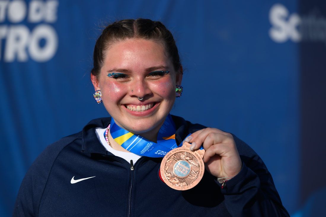 Alicia Guerrero smiles and holds up her bronze medal in Santiago