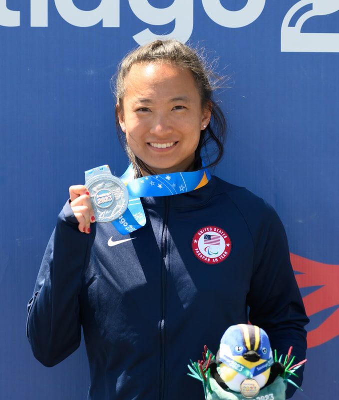 Taylor Swanson smiles and holds up her silver medal in Santiago