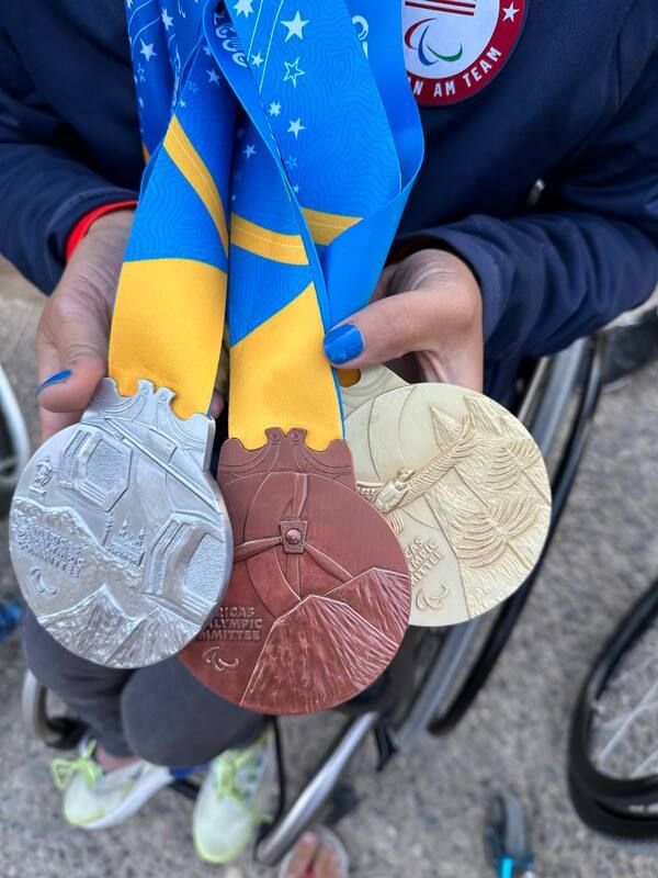 Gold, silver and bronze Santiago 2023 medals held up together