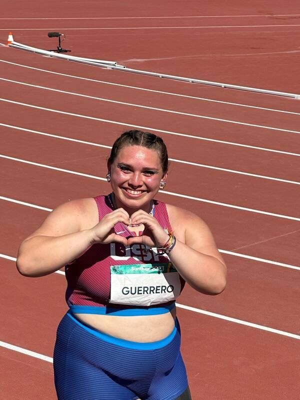 Team USA thrower makes a heart shape with her hands on the track