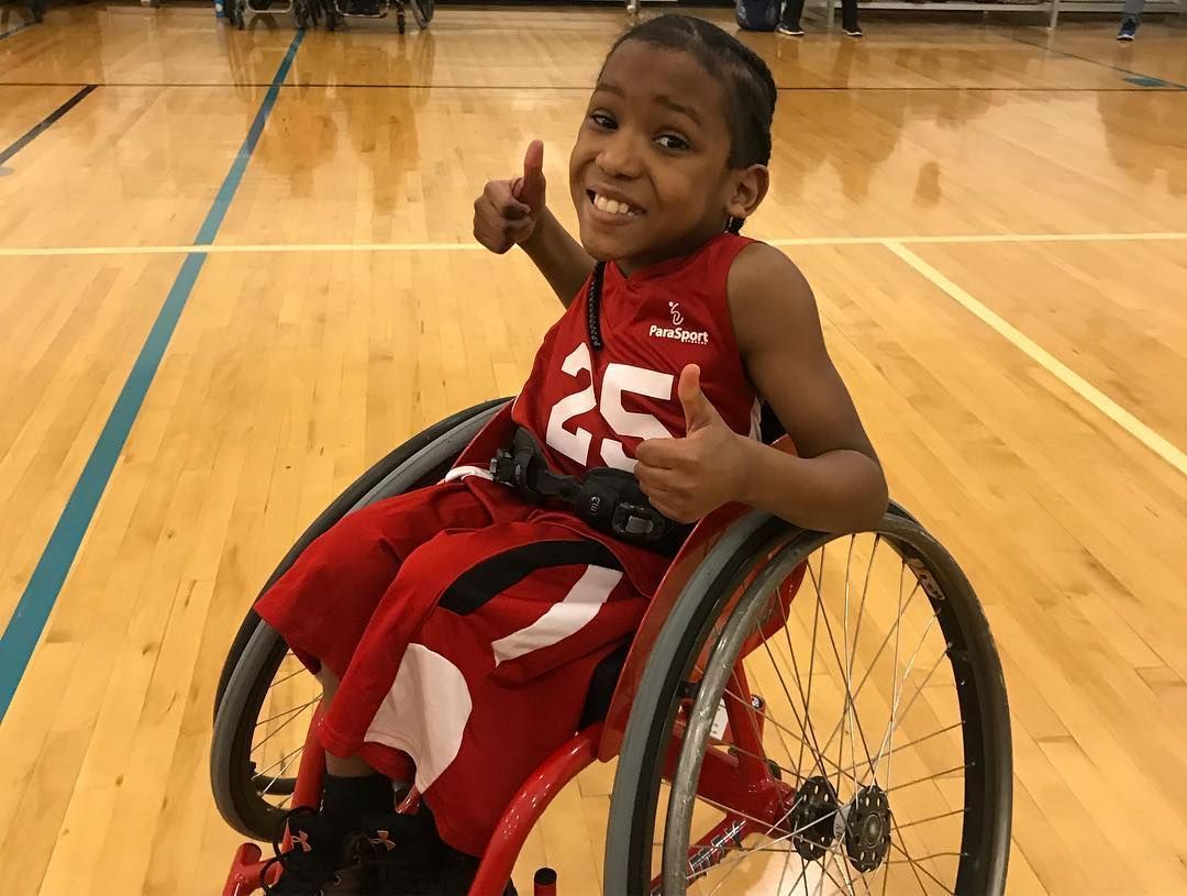 Smiling young player in red jersey 25 gives two thumbs up on the court