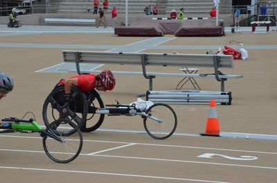 Racer in a red helmet chases another past an orange cone