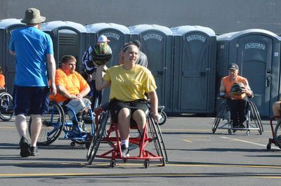 Player in a yellow shirt rolls forward in a red sport wheelchair