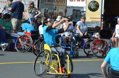 Player in a light blue shirt winds up a shot from a yellow wheelchair